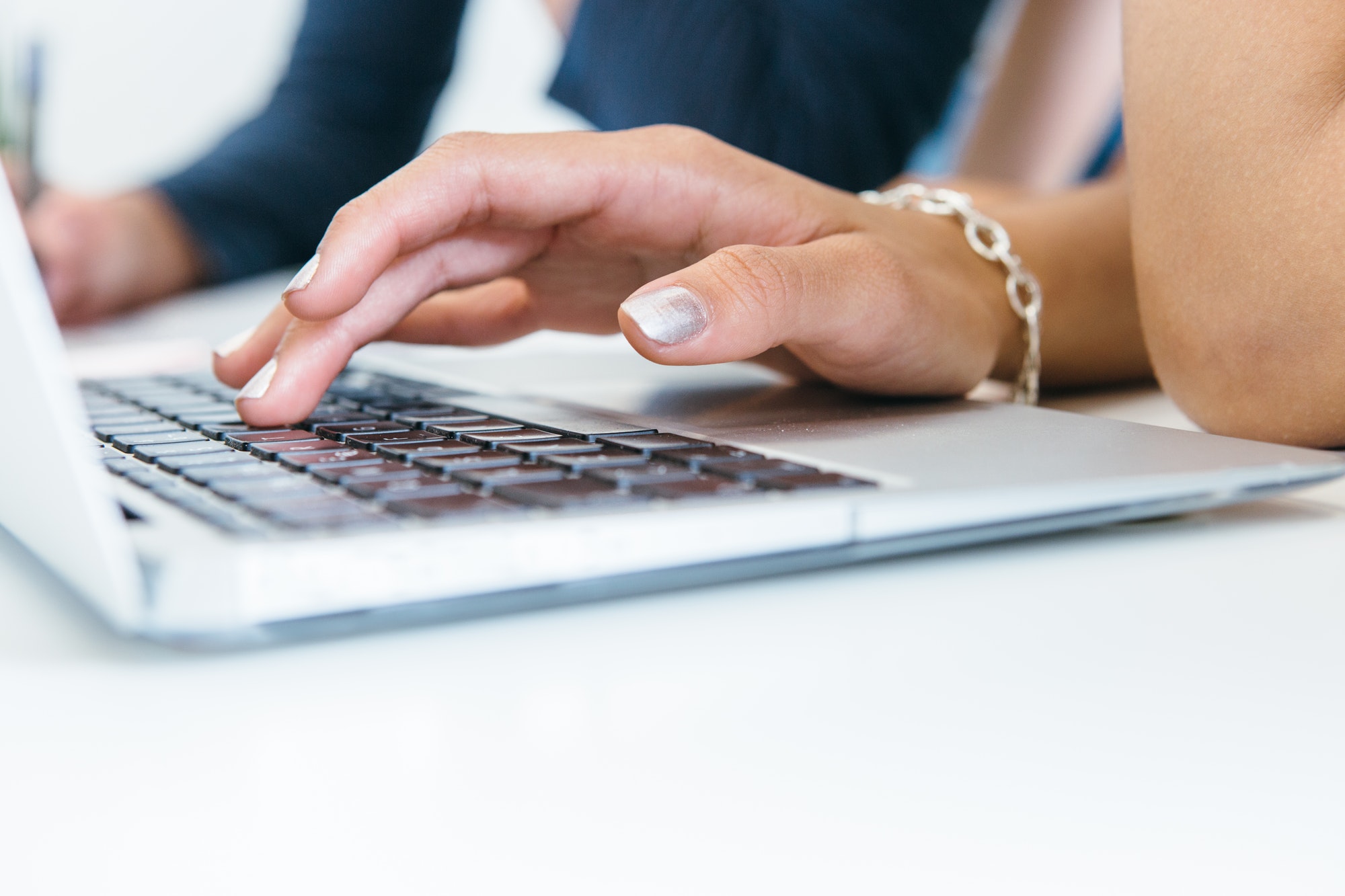 Crop woman using laptop