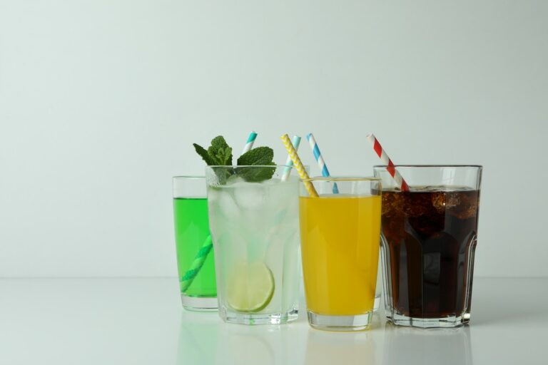 Glasses of different soda on white background