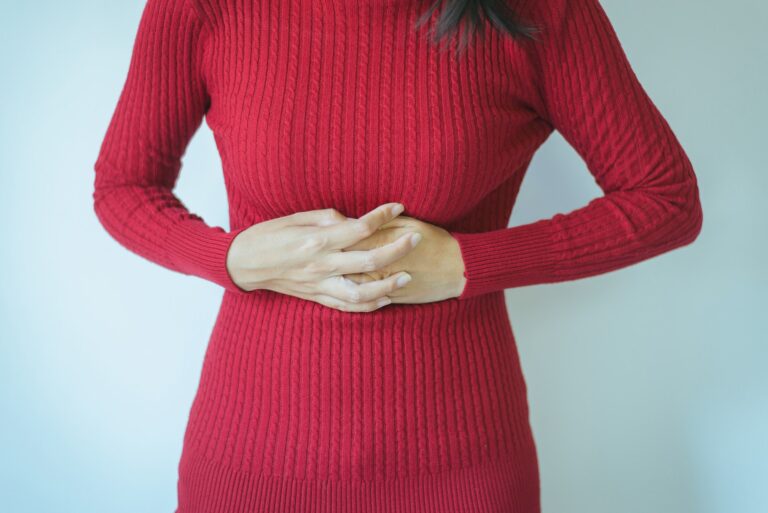 Woman hand holding on stomach suffering from abdominal pain