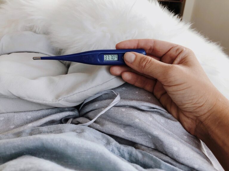 Woman in bed having fever holding fever scan