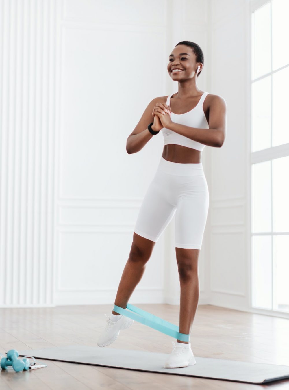 Happy African Woman In Sportswear Exercising With Elastic Band